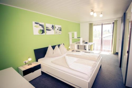 法克湖瓦德鲁塔内海姆旅馆的卧室配有白色的床和绿色的墙壁