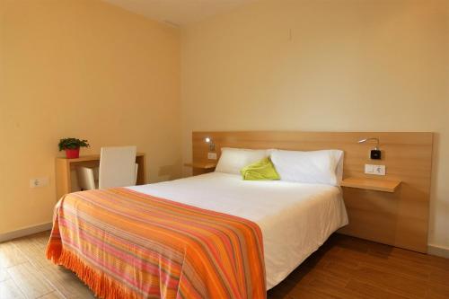 QuesaHotel de Montaña La Rocha的一间卧室配有一张带彩色毯子的床