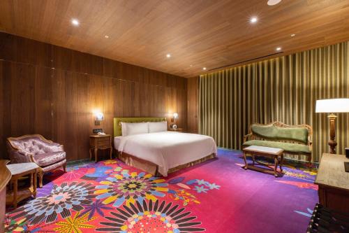 台中市薆悦酒店五权馆的酒店客房,配有床和色彩缤纷的地毯