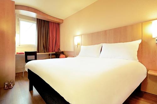 里尔宜必思加雷斯里尔中心酒店的一张大白色的床,位于酒店客房内