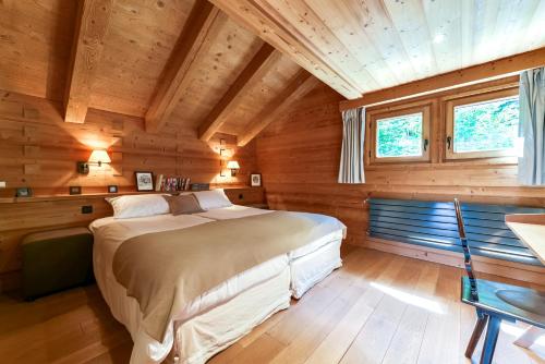 里雾诗Chalet Noemie的木制客房内的一间卧室配有一张大床