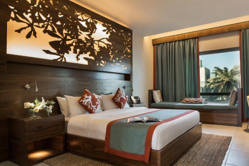 科威特棕榈海滩温泉酒店的一间卧室设有一张大床和一个窗户。