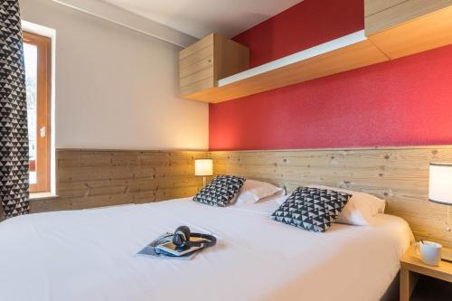 拉塔尼亚不列颠尼亚玛伊瓦公寓酒店的卧室配有白色的床铺和红色的墙壁