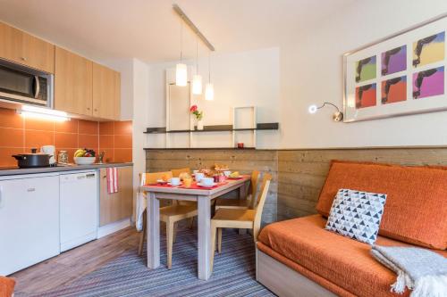 拉塔尼亚不列颠尼亚玛伊瓦公寓酒店的厨房以及带桌子和沙发的用餐室。