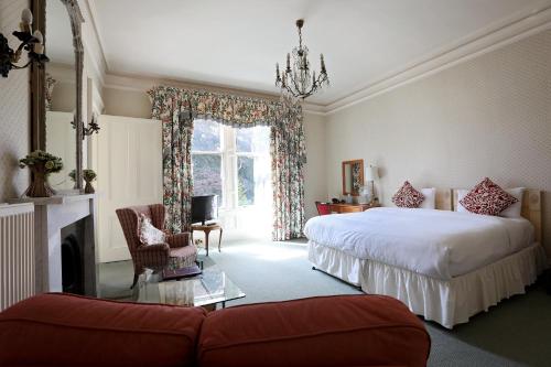加拉希尔斯Kingsknowes Hotel的一间卧室设有两张床、一张沙发和一个壁炉