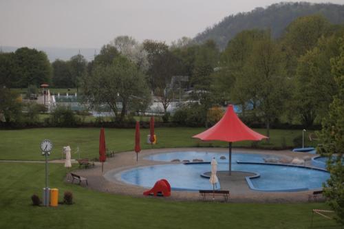 蒂宾根拜德酒店的公园里一个带红伞的大型游泳池