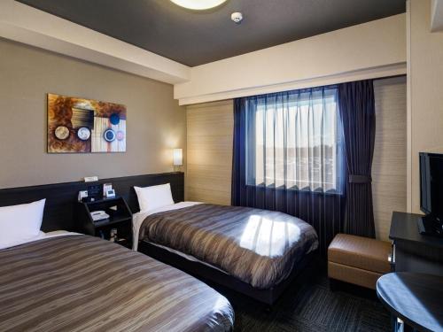 Hotel Route-Inn Ishioka客房内的一张或多张床位