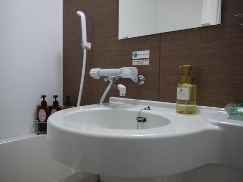 IshiokaHotel Route-Inn Ishioka的浴室设有白色水槽和镜子