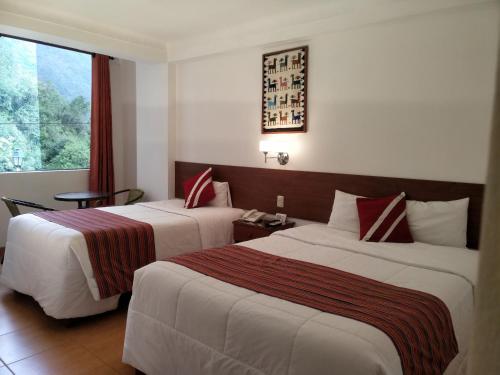 马丘比丘Viandina Machupicchu的酒店客房设有两张床和窗户。