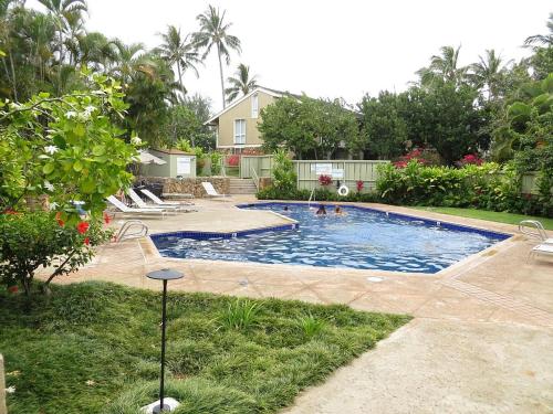 卡胡库Elegant Turtle Bay Condo的一座带房子的庭院内的游泳池