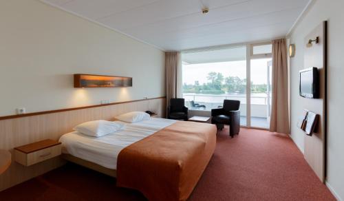 埃尔讷沃德普林斯霍夫酒店的配有一张床、一张书桌和一扇窗户的酒店客房