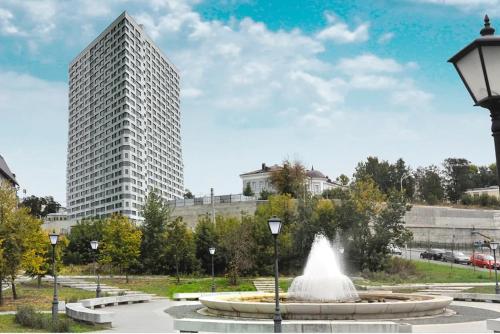 喀山摩天大楼公寓 的公园里的一个喷泉,有一座高大的建筑
