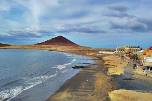 厄尔梅达诺El Medano - Cerca de la Playa的享有海滩美景,背景为山脉