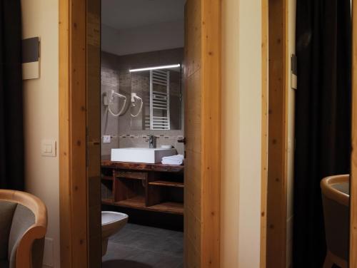 科雷多Garni Le Maddalene的一间带水槽、卫生间和镜子的浴室