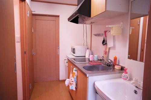 神户Takaraboshi room 301 Sannomiya 10 min的一间带水槽和微波炉的小厨房