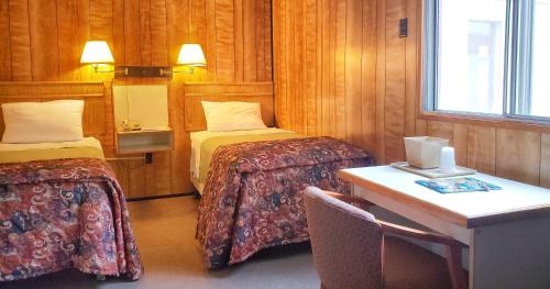 瓦尔迪兹基斯通酒店的客房设有两张床、一张桌子和一张书桌。