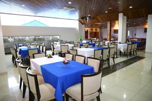 南克鲁兹罗Swamy Hotel的一间配备有桌椅及蓝桌布的用餐室