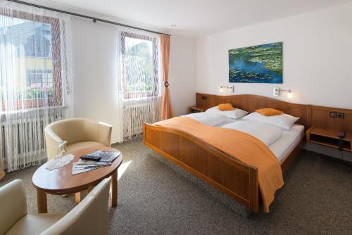 莱温维恩豪斯韦斯酒店的一间卧室配有一张大床、一张桌子和一把椅子