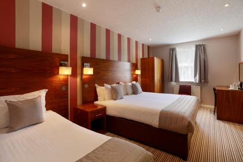 坎特伯雷维多利亚酒店的酒店客房设有两张床和条纹墙