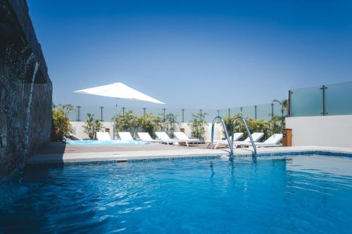 皮乌拉皮乌拉温德姆科斯塔朗晴酒店的度假村内带躺椅的游泳池