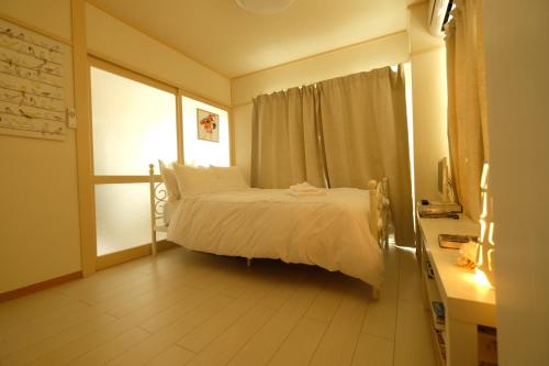 东京COCO Nakameguro 201的卧室配有白色的床和窗户。