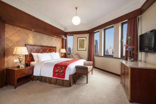 上海上海锦江国际饭店的酒店客房,配有床和电视