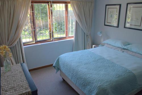 普利登堡湾Menlo At C的一间卧室设有一张床和两个窗户。