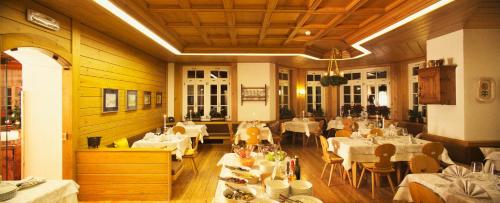 帕索圣佩莱格里诺科斯塔贝拉酒店的用餐室配有白色桌椅和桌子。