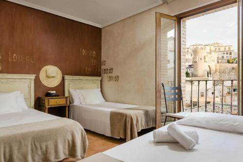 托莱多YIT Puerta Bisagra的酒店客房设有两张床和一个阳台。