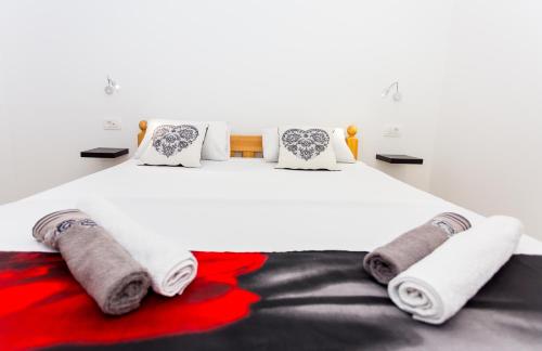 杜埃Luxury suites Juričević的卧室配有白色床、毛巾和枕头