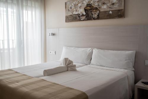 阿尔巴塞特玛索公寓的一张白色的床,上面有弓