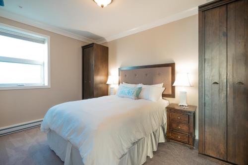 苏克SookePoint Ocean Cottage Resort的卧室设有一张白色大床和一扇窗户。