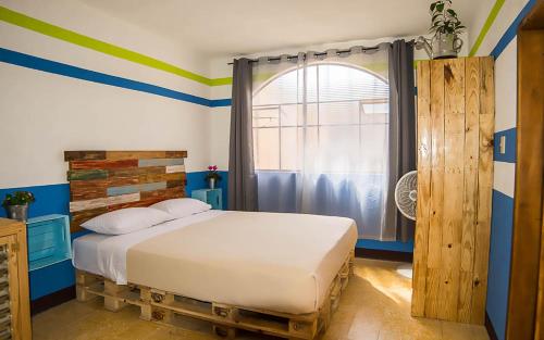 危地马拉安地瓜The Purpose Hostel的一间卧室配有一张蓝色和绿色条纹的床
