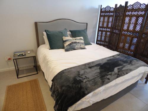 SibayaOcean Dune Studio的一间卧室配有一张大床、枕头和桌子