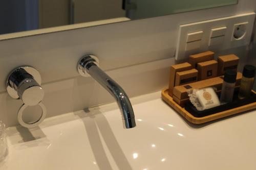 萨拉曼卡Salamanca Suites Libertad的浴室水槽配有水龙头和肥皂盘
