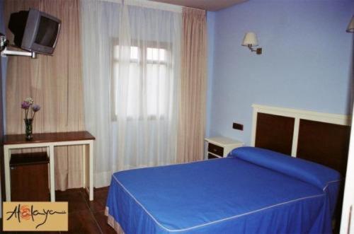 里奥廷托矿区阿塔拉亚旅馆的一间卧室配有蓝色的床和电视