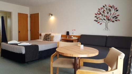 基督城阿尔顿酒店的酒店客房配有床、桌子和沙发。
