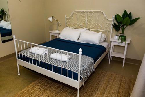 黄金海岸库兰加塔金沙酒店的卧室配有白色床、蓝色床单和白色枕头