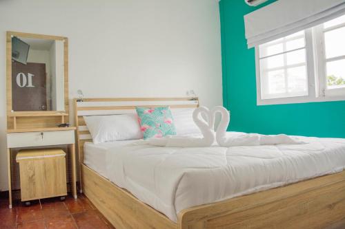 华欣Karoon hut的一间卧室配有一张带天鹅装饰的床。