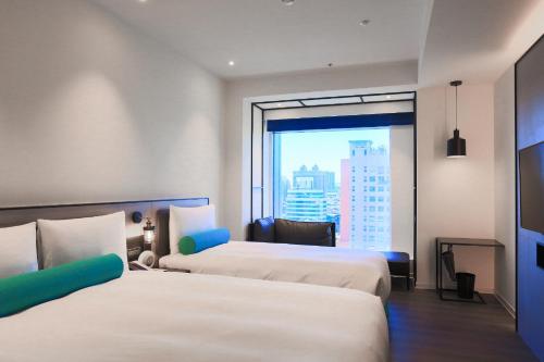 台北台北凯达大饭店的酒店客房设有两张床和大窗户。