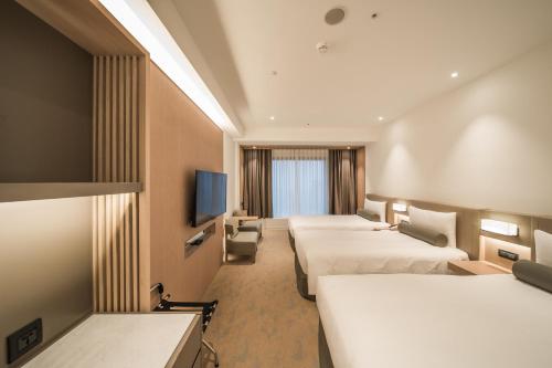 台北台北凯达大饭店的酒店客房设有四张床和平面电视。