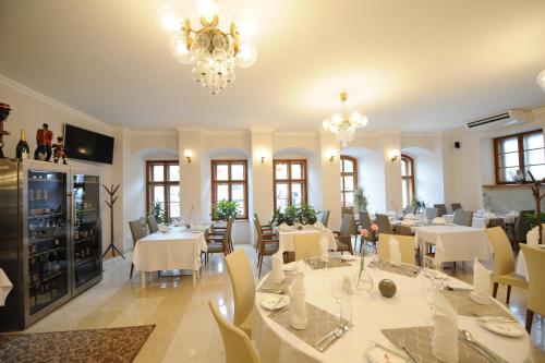特普利采王子利涅酒店的餐厅配有白色的桌椅和吊灯