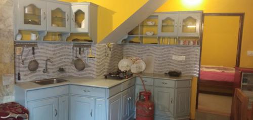 可瓦兰Wilson Ayurvedic Beach Resorts的厨房配有蓝色橱柜和水槽