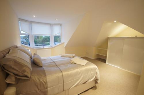 格拉斯哥Modern, Cosy Apartment In Bearsden with Private Parking的一间卧室设有一张床和一个窗口