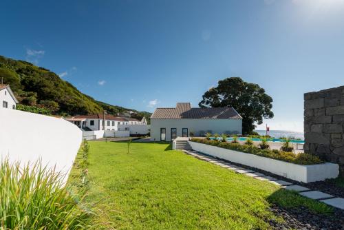 Calheta de NesquimT2 Lux Casa das Pereiras的享有带房屋的庭院和大海的景致