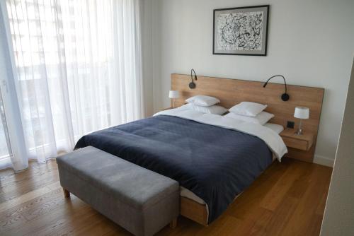 楚格Zug Downtown Apartments的一间卧室设有一张大床和一个大窗户