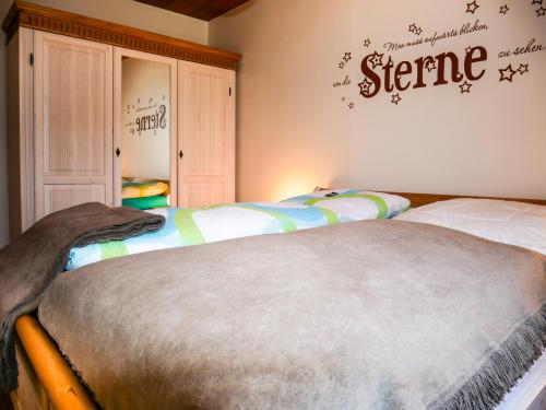费马恩Ferienwohnung am Dorfteich的卧室配有两张床,墙上有标志