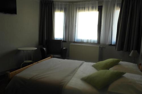 安蓓祖姆金哈恩旅馆的一间卧室设有一张大床和一个窗户。