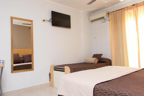 费德拉西翁瓦勒俱乐部铁尔玛鲁度假村的一间卧室设有两张床、镜子和电视