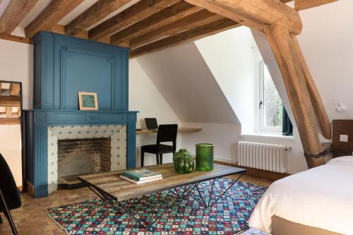 翁弗勒尔Le Manoir de la Plage / Adults Only的一间卧室设有蓝色壁炉和一张床